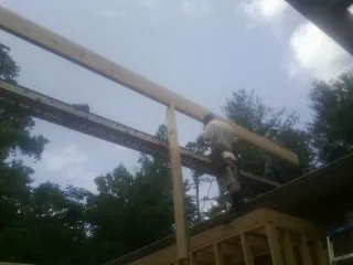 Carpenter setting a ridge beam over a new addition frame — Ice Dam Removal by Roofing Brothers in Yorktown