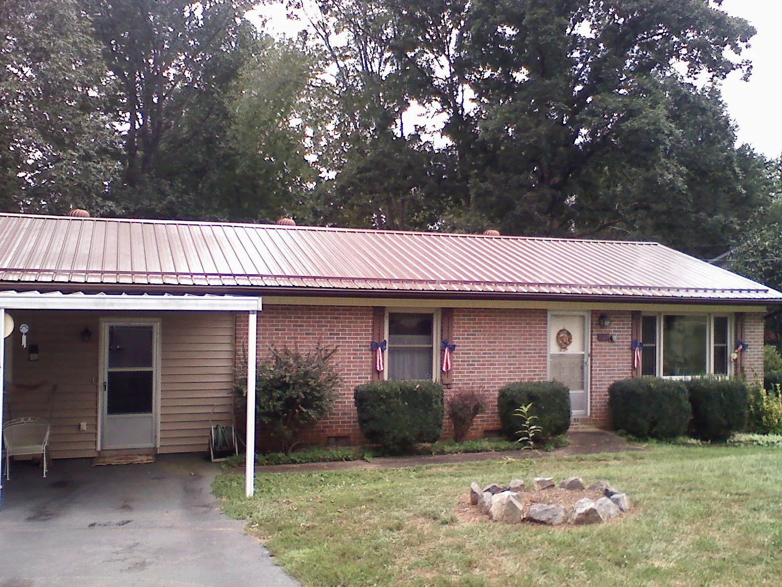 Bronze metal roof and carport on a brick ranch home — Roof Repair work by our crew in Yorktown